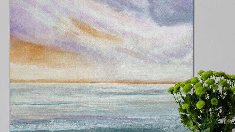 The coast/sea painting standing on the wooden floor, next to a flower vase.