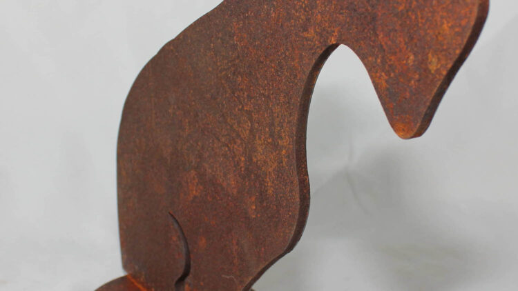 An oxidised stell dog figure, standing in a photo-setup