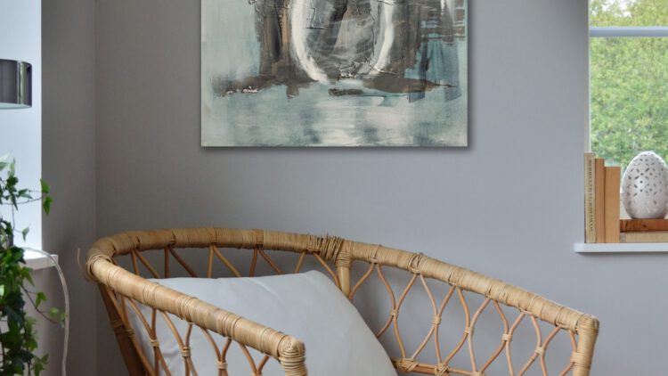 The painting of yellow flowers in a vase hanging on the wall in the corner of a room.